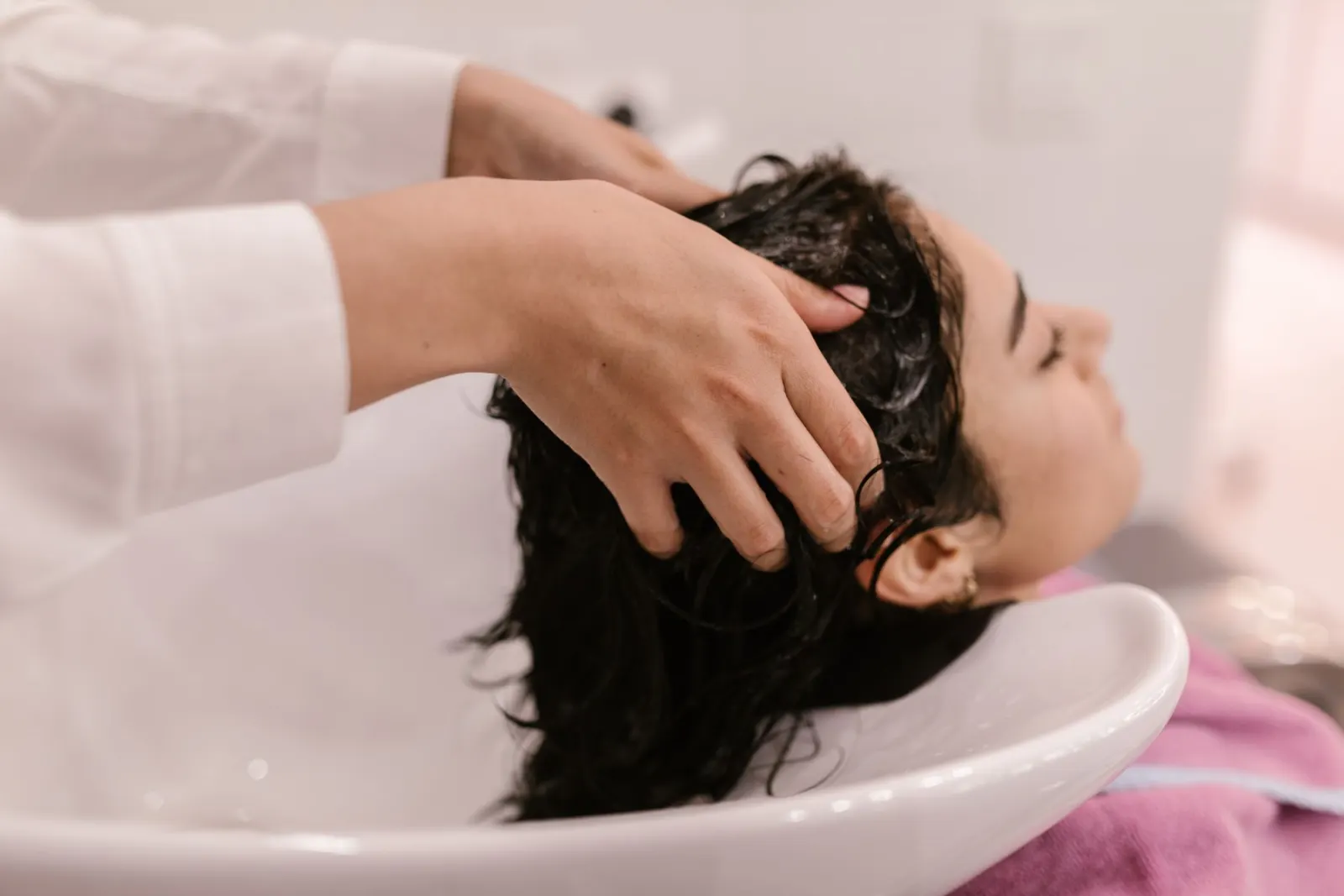 Therapist washing a guest’s hair during a head spa treatment